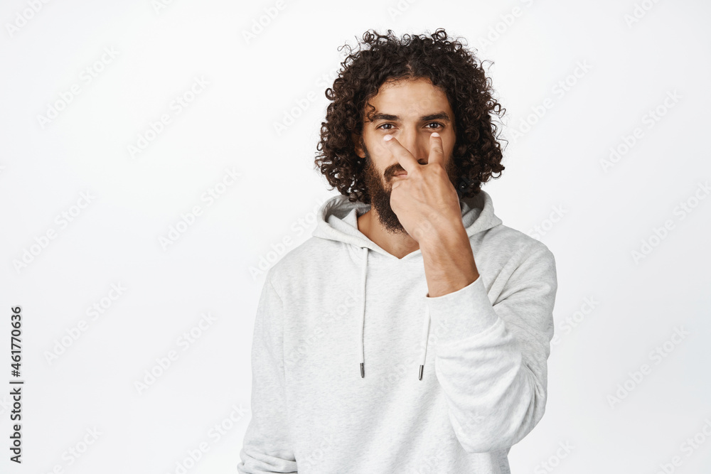 I am watching you. Serious guy making eye contact gesture, being suspicious, standing over white background I am watching you. Serious guy making eye contact gesture, being suspicious, standing over white background