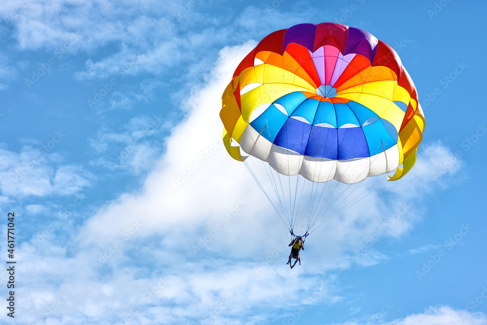 Paragliding using a parachute on background of blue cloudy sky. - obrazy, fototapety, plakaty 