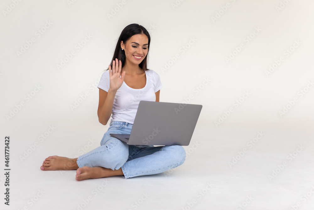 Naklejka premium Happy young woman chatting on conference video call looking at laptop isolated on white background
