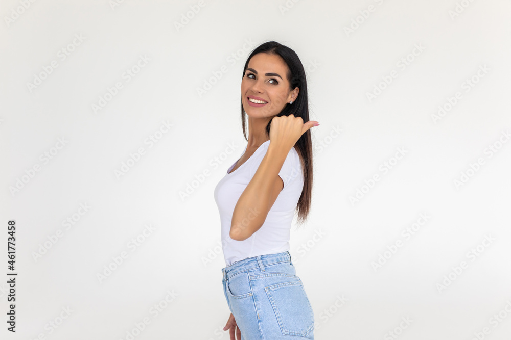 Young woman smiling and looking into the camera. Pointing at something behind her with her hands isolated on white background. Young woman smiling and looking into the camera. Pointing at something behind her with her hands isolated on white background.