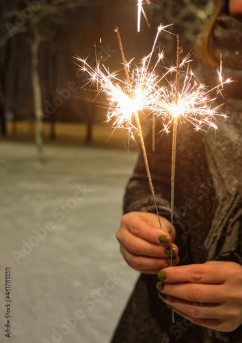 hand with a sparkler on the background of night lights. festive lighting of the city with a sparkler on the background of night lights. festive lighting of the city