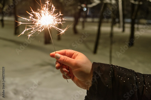 hand with a sparkler on the background of night lights. festive lighting of the city with a sparkler on the background of night lights. festive lighting of the city
