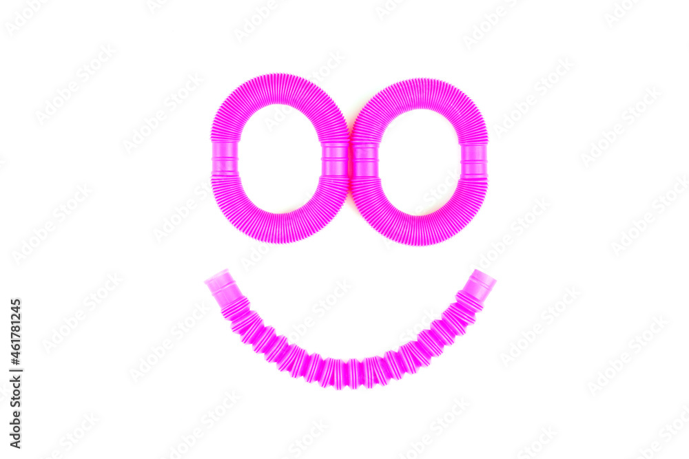 Smile from plastic corrugated tube, pop tube. trending toy of 2021. anti-stress sensory plastic toy from a tube of pink and blue color on an isolated white background. Flat lay with place for text. Smile from plastic corrugated tube, pop tube. trending toy of 2021. anti-stress sensory plastic toy from a tube of pink and blue color on an isolated white background. Flat lay with place for text.