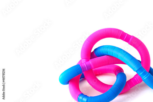 pop tube trending toy of 2021. anti-stress sensory plastic toy from a tube of pink and blue color on an isolated white background. Corrugated metamarphosis. Flat lay with place for text. photo