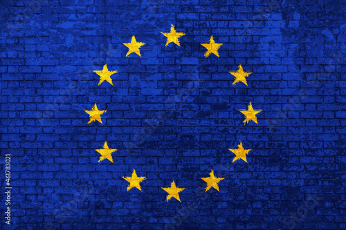 wall of bricks painted with the flag of Europe, blue with yellow stars. 3d background. Concept of social barriers of immigration, divisions, and political conflicts in Europe.