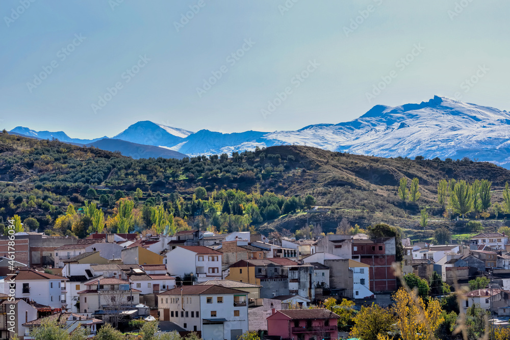 View of the Spanish town Beas de Granada, in Andalucia, on an autumn morning with the snow-covered Sierra Nevada in the background