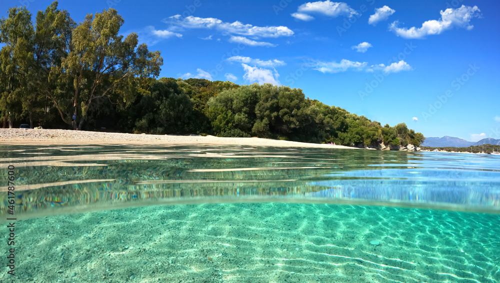 Fototapeta premium Beautiful underwater split above and below photo of rocky seascape with deep blue sky and clouds and rich marine life in tropical exotic island destination