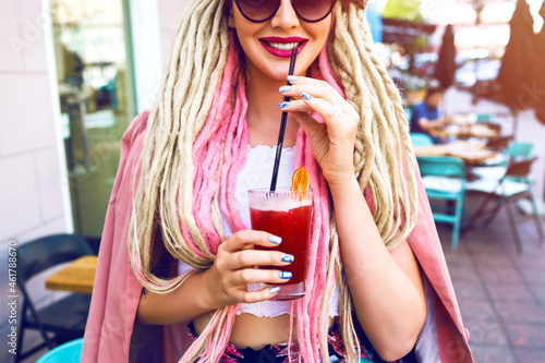 Young pretty smiling woman posing at outdoor city cute cafe