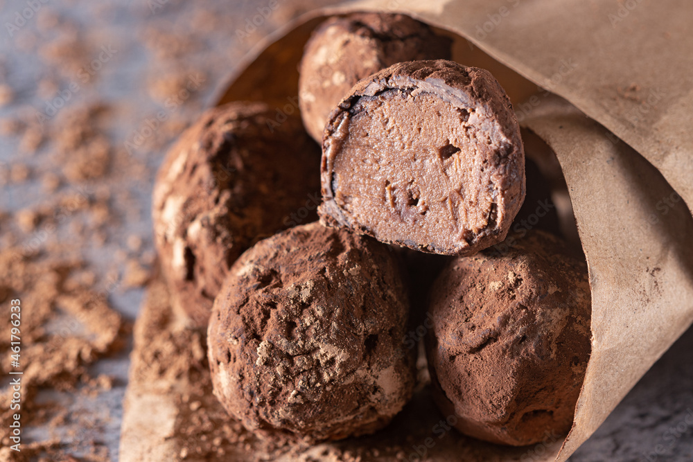 Fototapeta premium chocolate truffles in a paper bag, sprinkled with cocoa