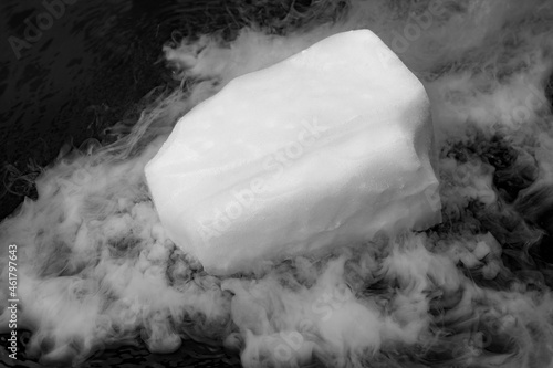 Dry ice evaporates in the water. Steam from a large piece of ice. Chemical experiment. photo