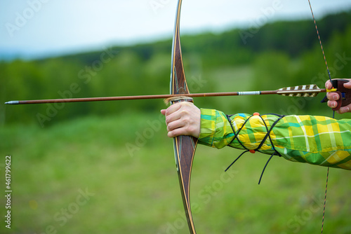 Obraz na plátne professional archer shooting with modern longbow in forest