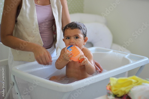 criança ensaboada tomando banho photo