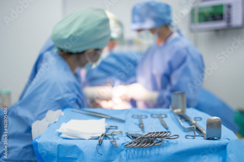 A close up photo of  surgeons 's instrument include scissors, forceps and surgical instruments on table for operation with colleagues performing work in operation room at hospital, emergency surgery. photo
