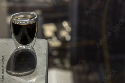 Black coffee in glass cup on marble table in the morning. Coffee style, Copy space, Selective focus.
