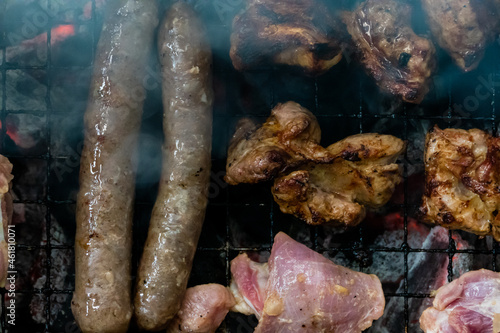 Top view of sausage and meat grilling on barbecue