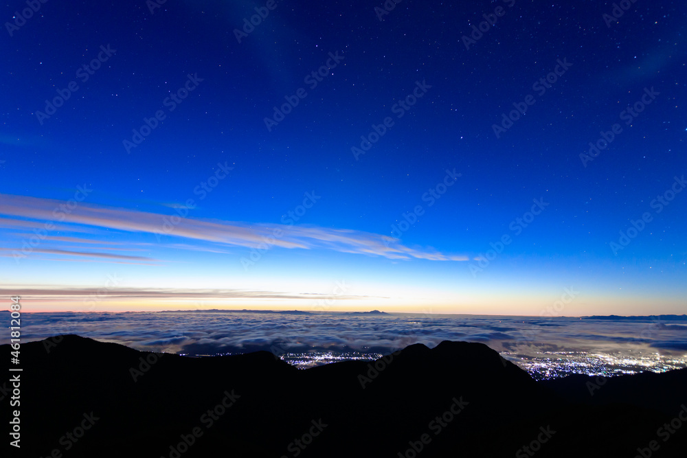 燕山荘展望台から望む明け方の星空と雲の下に見える街の灯り