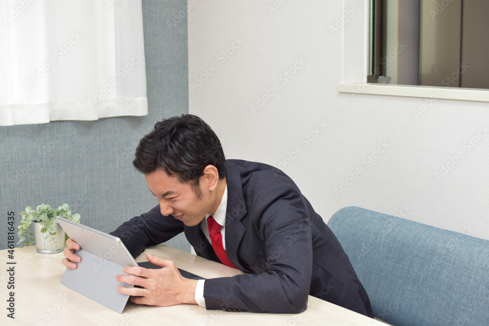 A young Asian man during telework at home gets angry and shows his emotion to the pc A young Asian man during telework at home gets angry and shows his emotion to the pc