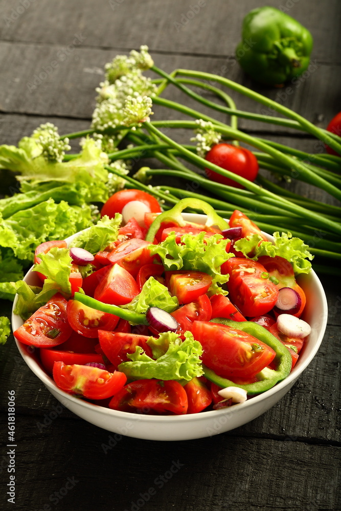 Homemade organic tomato green vegetable salad served in white ceramic bowl. diet meal. Homemade organic tomato green vegetable salad served in white ceramic bowl. diet meal.