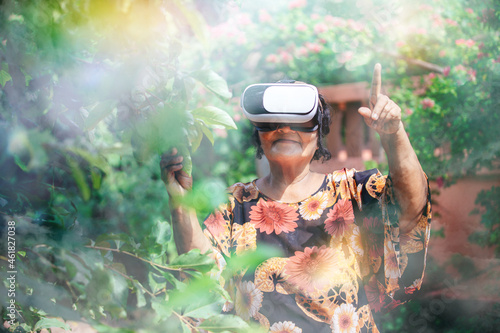 Seniors in virtual reality glasses playing the game. Older woman with vr headset in garden  concept of virtual travel or vr immersion in game. Modern technology concept