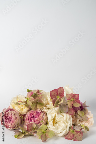 flower composition of roses and hydrangea flowers closeup on a white background. wedding day greeting card. Vertical photo and copy space.