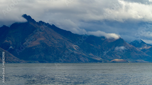dark, misty mountain with low rolling clouds and lake