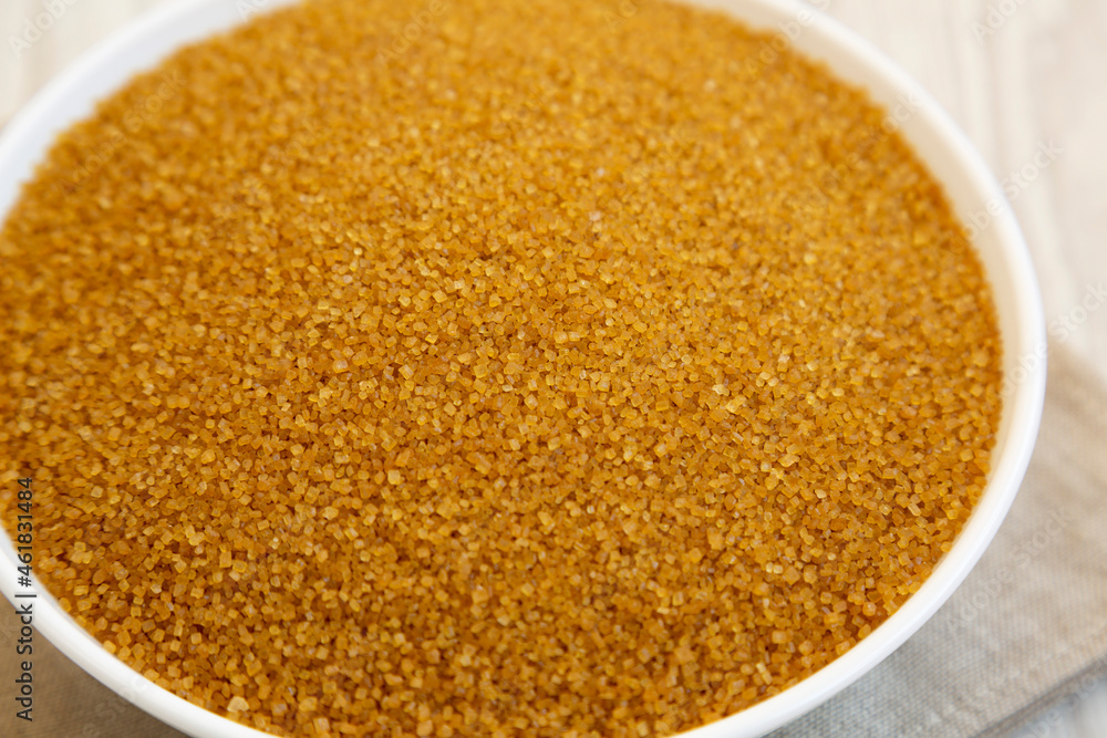 Organic Brown Sugar in a White Bowl, low angle view. Close-up.