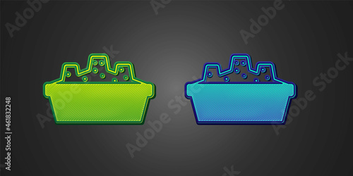 Green and blue Sandbox for kids with sand icon isolated on black background. Vector