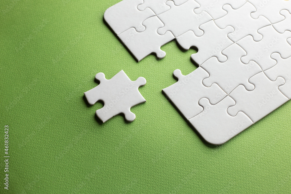 Obraz premium a piece fails to complete a jigsaw because of its shape and incompatibility. green background. copy space. work team. space for text.