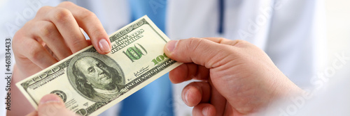 Female doctor hold hundred dollars banknote
