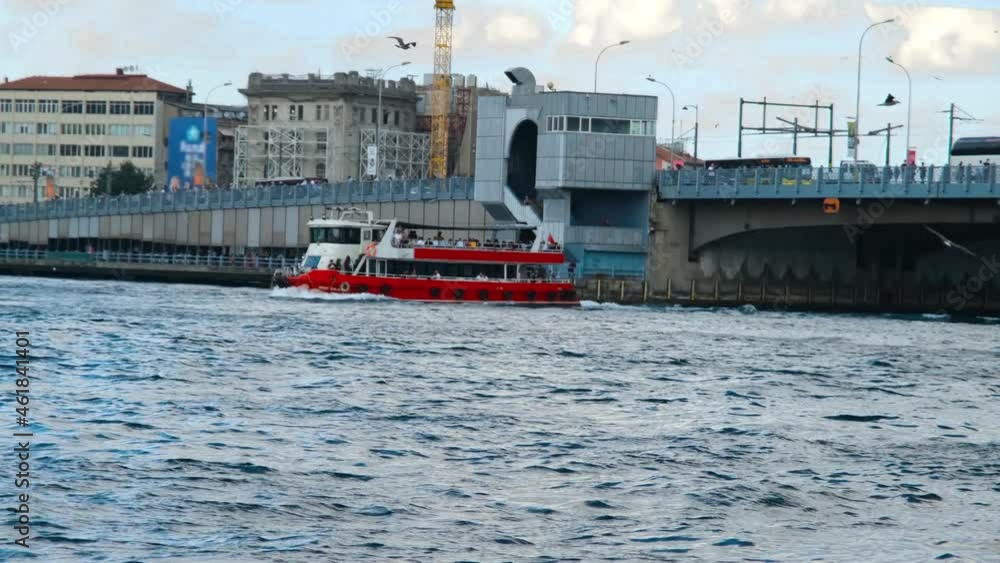 boat passing, red boat passing under the bridge, galata bridge in istanbul