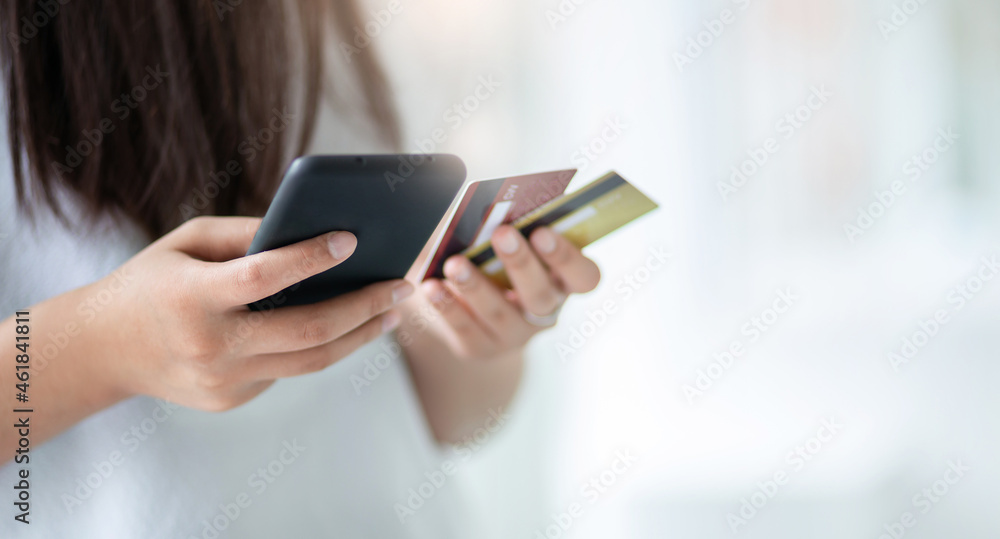 Focus on hand young asian woman holding mobile phone and using mobile app to shopping or paying online Focus on hand young asian woman holding mobile phone and using mobile app to shopping or paying online