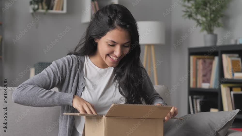 happy woman sits on the couch open online order cardboard box,satisfied female customer opening,unboxing postal parcel package,home shipping delivery concept happy woman sits on the couch open online order cardboard box,satisfied female customer opening,unboxing postal parcel package,home shipping delivery concept