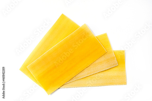 Uncooked raw lasagna pasta isolated on white background. Stack of dried uncooked lasagna pasta sheets