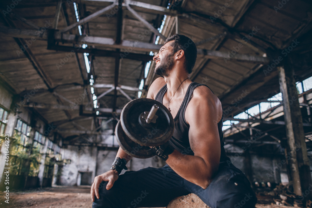 Muscular Strong Handsome Man Lifts a Weight and does Bodybuilding in a Dirty Empty Hall Muscular Strong Handsome Man Lifts a Weight and does Bodybuilding in a Dirty Empty Hall