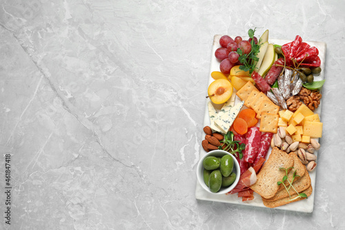 Different tasty appetizers on light marble table, top view. Space for text
