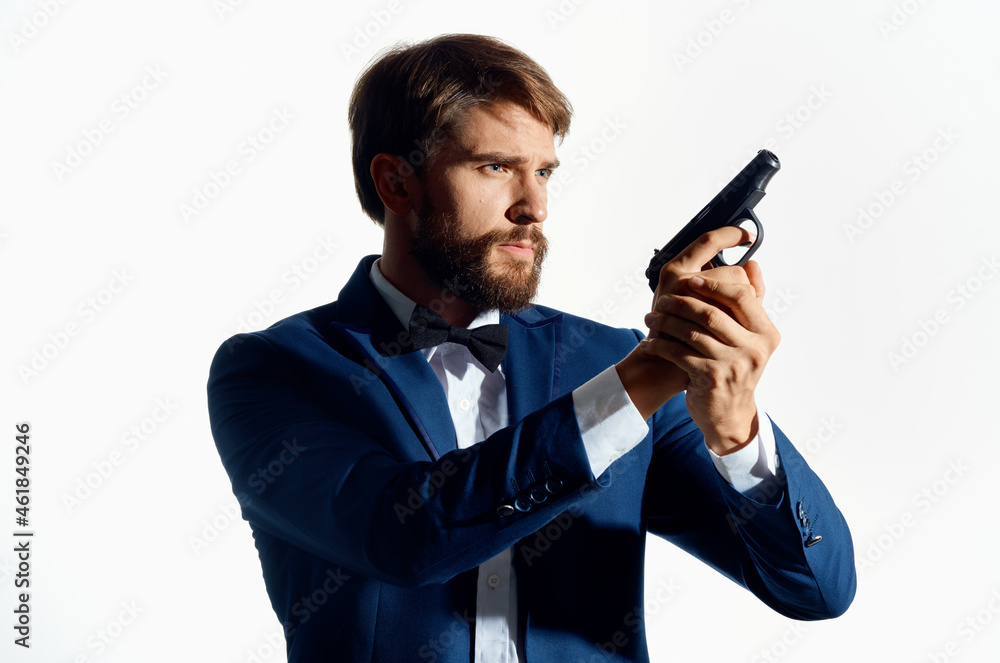 male gangster with a gun in hand light background male gangster with a gun in hand light background