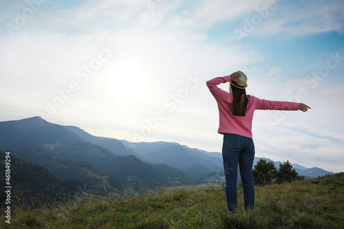 Woman enjoying mountain landscape, back view. Space for text © New Africa