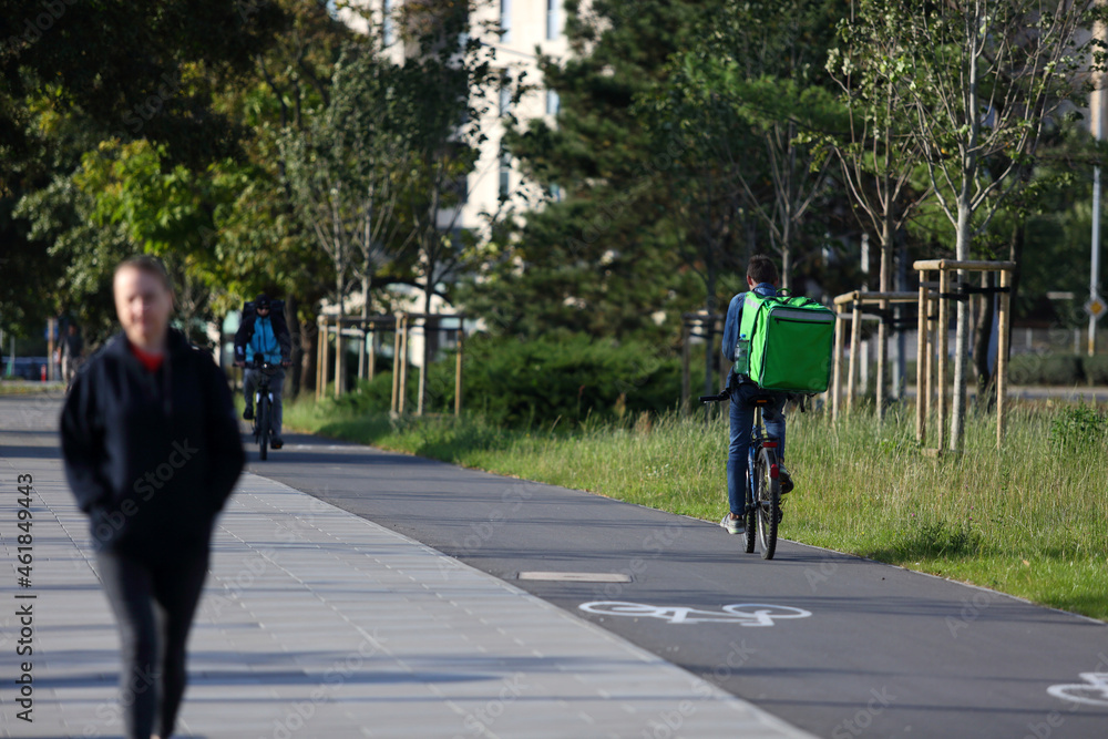 Kurier na rowerze dostarcz smaczne jedzenie na ulicach miasta. - obrazy, fototapety, plakaty 