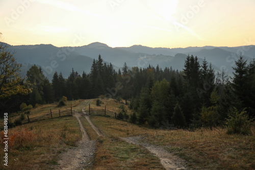 Picturesque view of mountain landscape with forest and wooden fence