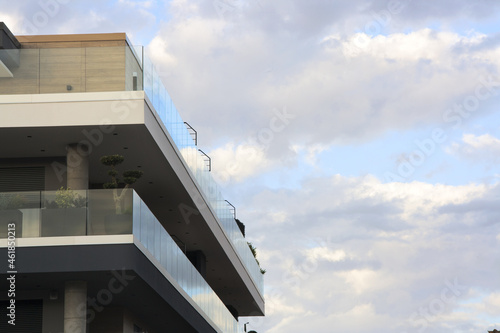 Glass balcony of the modern building reflect the cloudy sky.