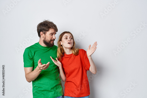 married couple multicolored t-shirts communication quarrel light background