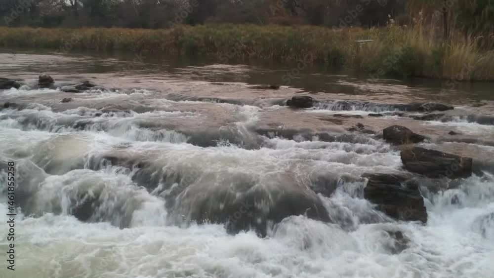 Fast-flowing white water running over and between rocks very close up view looking up the Okavango river Aerial Video. Popa waterfalls Okavango river Fast-flowing white water running over and between rocks very close up view looking up the Okavango river Aerial Video. Popa waterfalls Okavango river