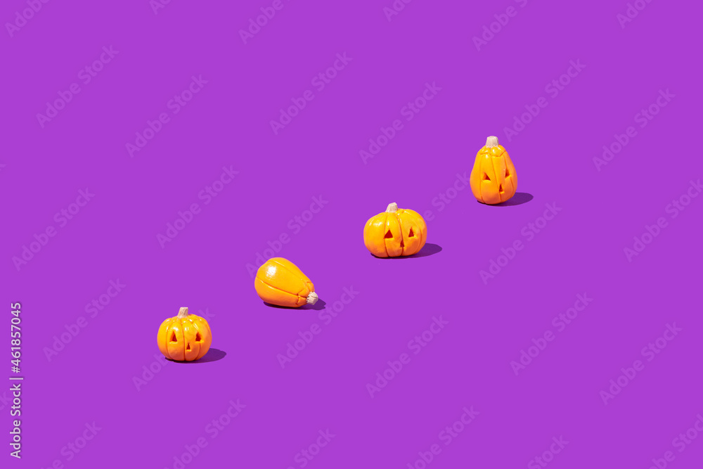 Pattern made of pumpkins on a purple background. Minimalistic Halloween concept. Creative idea.