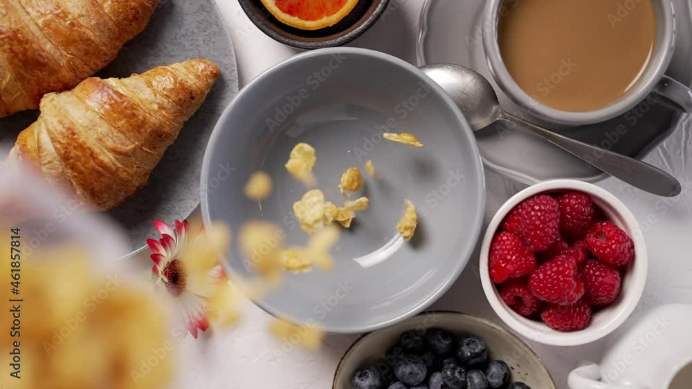Pouring cornflakes into breakfast bowl. Falling from above Pouring cornflakes into breakfast bowl. Falling from above