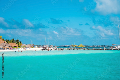 Cancun, Mexico. May 30, 2021. Yachts or sailboats sailing on beautiful turquoise sea water surface against cloudy sky