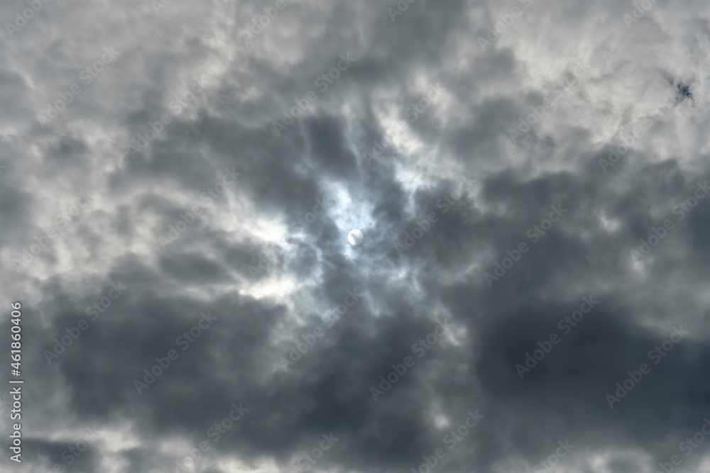 View of the white solar disk in the dark clouds. No land view.
