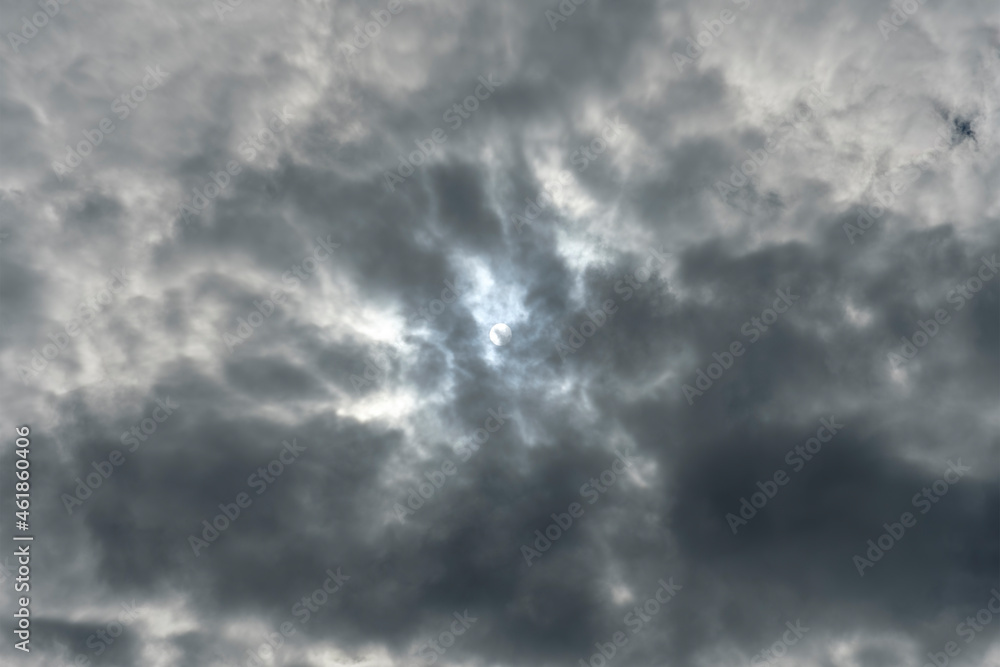 View of the white solar disk in the dark clouds. No land view. View of the white solar disk in the dark clouds. No land view.