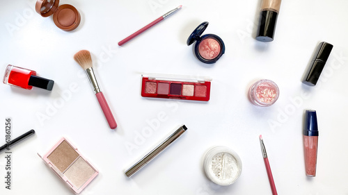 Beauty concept. Makeup products shadows, highlighter, blush, brushes, powder, glitter, mascara, gloss, lipstick, pencil on white background