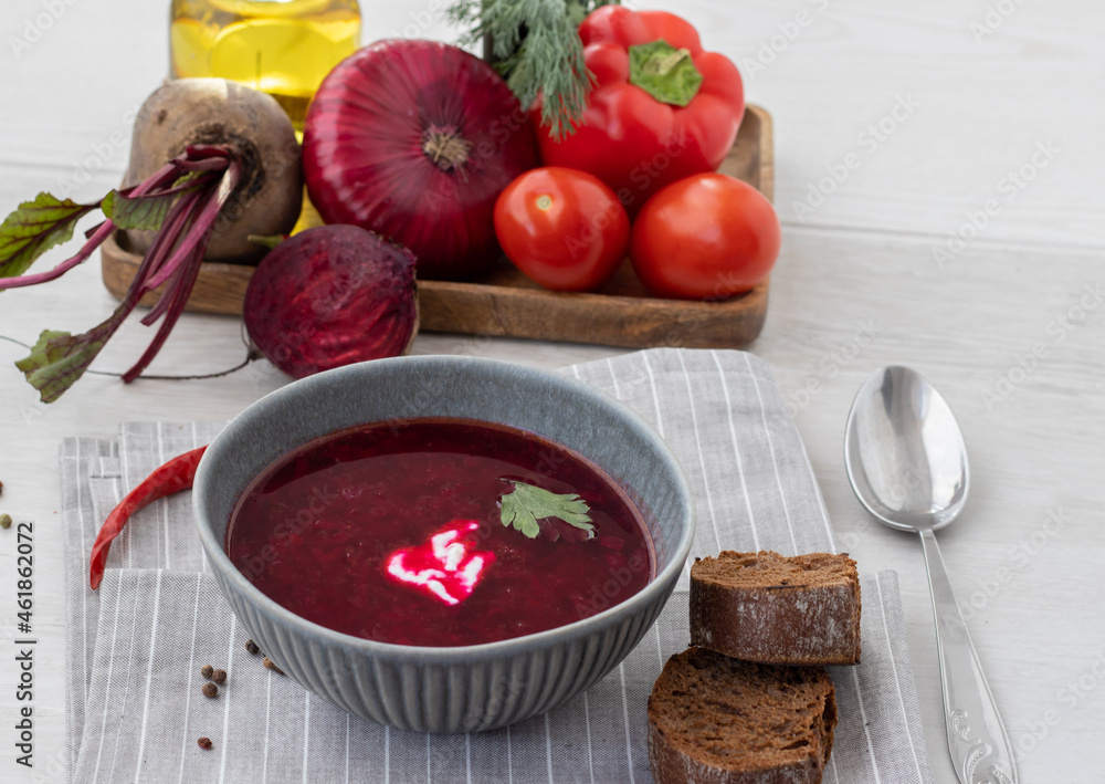 Beetroot soup with bread and veggies on a white background Beetroot soup with bread and veggies on a white background