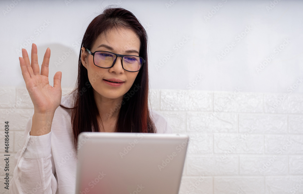 Asian working at home using tablet device, video call meeting with friend. Asian working at home using tablet device, video call meeting with friend.